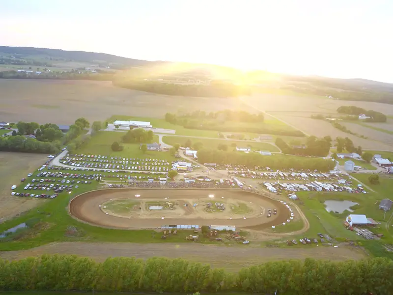 Drone view of the quarter-mile 35 Raceway Park dirt oval at sunset, surrounded by farmland