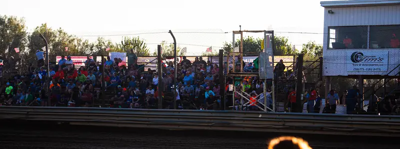 Packed grandstand at 35 Raceway Park at sunset
